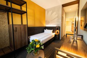 a hotel room with a bed and a table with flowers at Bundt's Hotel & Gartenrestaurant in Hamburg +63 photos