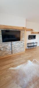 a living room with a flat screen tv on a brick wall at Stilvolle Wohnung in Waldbrunn in Waldbrunn