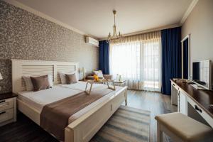 a bedroom with a large bed and a television at Sunny Castle Hotel - All Inclusive, Beach and Free parking in Kranevo +150 photos