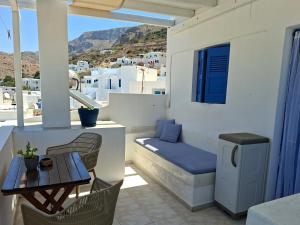 a balcony with a table and a bench and a table at Aegeon Pension in Aegiali