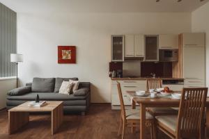 a kitchen and a living room with a table and a couch at Apartments Obernosterer in Kaprun