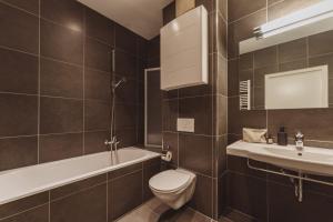 a bathroom with a toilet and a tub and a sink at Apartments Obernosterer in Kaprun +55 photos