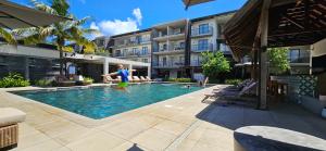 a young boy is playing in a swimming pool at Holiday - Comfort - Spacious - Escape in Grand-Baie