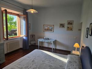 a bedroom with a bed and a table and a window at La Primavera B&B in Volterra