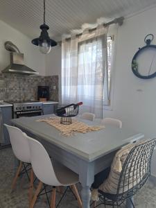 a kitchen with a table with chairs around it at Home Maro in Lefkimmi