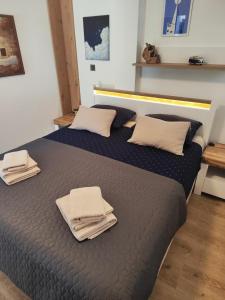 a bedroom with a bed with towels on it at Apartman Fjaka in Petrcane