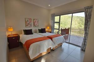 a bedroom with a large bed and a balcony at Igoda Mouth Resort in Winterstrand