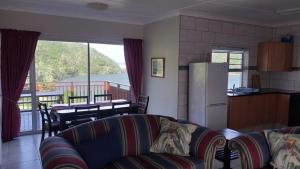 a living room with a couch and a kitchen with a table at Igoda Mouth Resort in Winterstrand