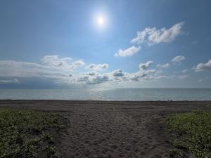 a sandy beach with the ocean on a cloudy day at Shekvetili Sunset Apartments in Shekhvetili