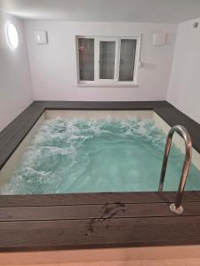 a large jacuzzi tub in a white room with at Krokusowa Przystań-SPA,Restauracja i Noclegi w Górach Sowich in Rzeczka