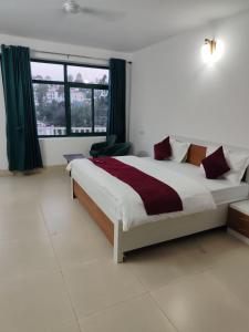 a bedroom with a large bed and a large window at Vybent hotel kainchi dham in Bhowāli