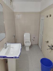 a bathroom with a white toilet and a sink at Vybent hotel kainchi dham in Bhowāli