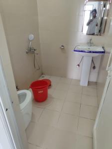 a bathroom with a toilet and a sink and a mirror at Vybent hotel kainchi dham in Bhowāli +12 photos
