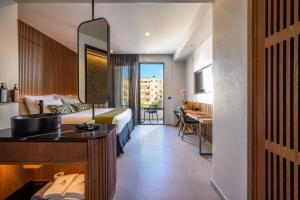 a hotel room with a bed and a sink and a desk at Anesea City in Heraklion