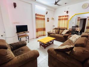 a living room with couches and a flat screen tv at Kamaleswari Villa Trincomalee in Trincomalee