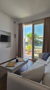 ein Wohnzimmer mit Sofa und Tisch in der Unterkunft Nostos in Patitiri
