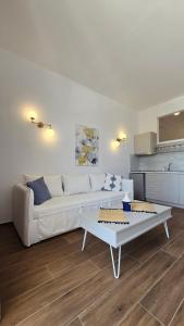 ein Wohnzimmer mit einem weißen Sofa und einem Tisch in der Unterkunft Nostos in Patitiri