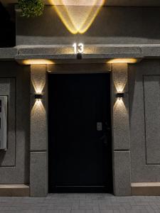 a building with a black door with lights on it at Sukoon Al Jubail in Al Fanātīr