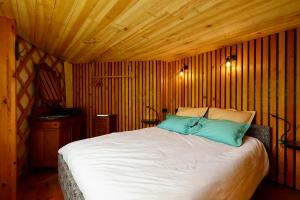 a bedroom with a large bed with wooden walls at Les Yourtes de La Valette in Floreffe