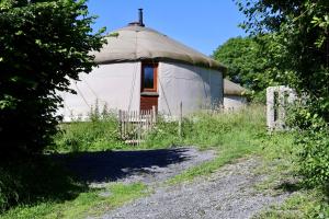 a yurt with a fence in front of a dirt road at Les Yourtes de La Valette in Floreffe