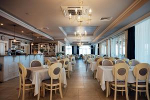 a dining room with white tables and chairs at Sunny Castle Hotel - All Inclusive, Beach and Free parking in Kranevo
