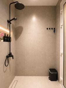a bathroom with a shower with a black stool at Sukoon Al Jubail in Al Fanātīr
