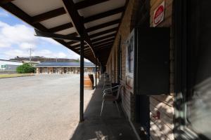 a building with a chair sitting on the side of it at The Argent Motel in Broken Hill +13 photos