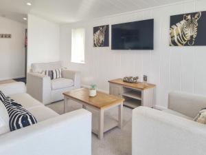 a living room with white furniture and a flat screen tv at Cherry Blossom 40 - Uk50709 in Garton