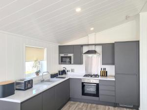 a kitchen with gray and white cabinets and appliances at Cherry Blossom 40 - Uk50709 in Garton
