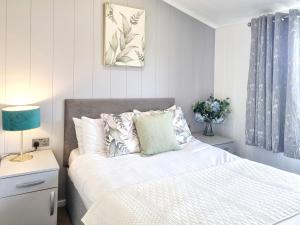 a bedroom with a bed with white sheets and pillows at Cherry Blossom 40 - Uk50709 in Garton +4 photos