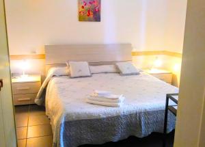 a bedroom with a bed with two towels on it at Hotel Pensione Moderna in Bonassola