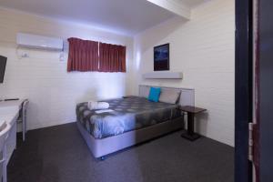 a bedroom with a bed and a desk in it at The Argent Motel in Broken Hill