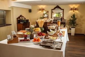 a buffet of fruit and vegetables on a table at Classic Inn Hotel in Braşov