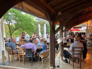 a group of people sitting at tables in a restaurant at camping du Coucou in Nailhac