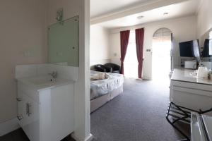 a bedroom with a bed and a sink and a mirror at The Argent Motel in Broken Hill