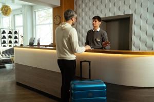 a man standing at a counter with his luggage at Long Vita in Przewóz +51 photos