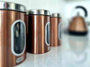 a row of copper coffee cups sitting on a counter at Cherry Blossom 39 - Uk50708 in Garton