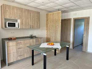 a kitchen with a table and a sink and a microwave at Albergue Hostel Barosa in Barro