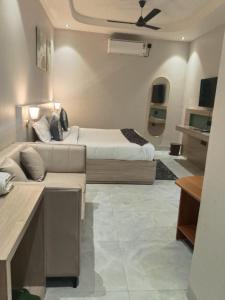 a hotel room with two beds and a couch at Yash Residency in Bharāwās