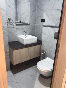a bathroom with a sink and a toilet at Yash Residency in Bharāwās