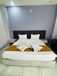 a large bed with two white towels on it at Yash Residency in Bharāwās