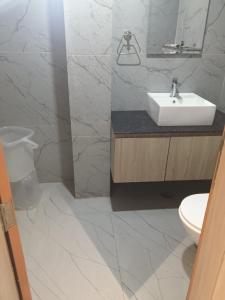 a white bathroom with a sink and a toilet at Yash Residency in Bharāwās