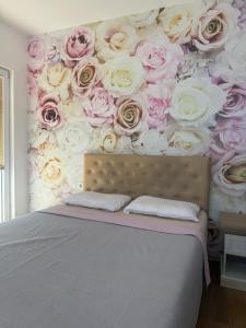 a bedroom with a wall covered in pink and white roses at Jorgovan in Bečići