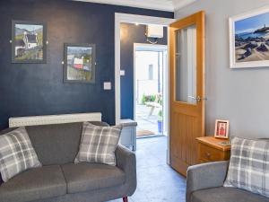 a living room with a couch and a chair at White Horses - Uk42776 in Newborough