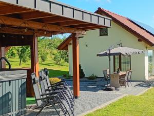 a patio with chairs and an umbrella and a table at Gawędówka in Czchów