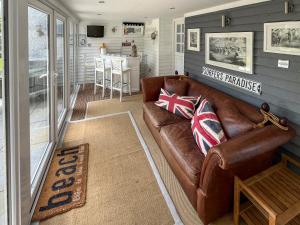 a living room with a brown leather couch at The Admirals in Sutton on Sea