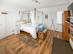 a bedroom with a bed with a canopy at The Admirals in Sutton on Sea +9 photos