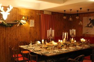 a dining room with a long table with candles at Hotel PIAN DEL SOLE Claviere in Claviere
