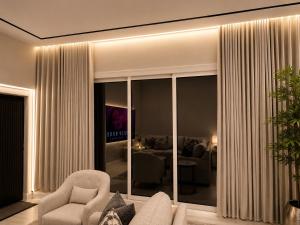 a living room with a couch and chairs in a room at Sukoon Al Jubail in Al Fanātīr