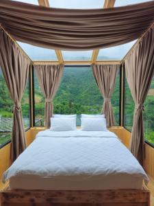 a bed in a room with a large window at Merisi Horizon in K'eda
